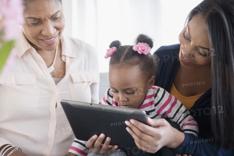 Black multi-generation family using digital tablet