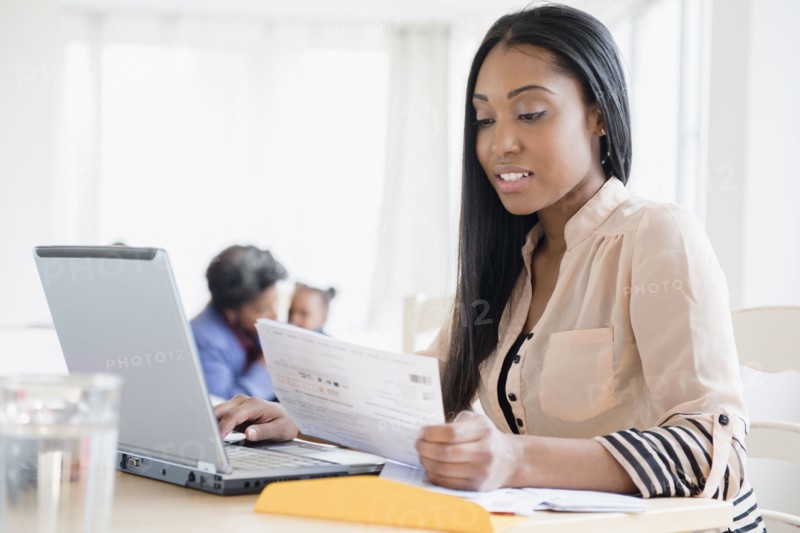 Black woman paying bills using laptop