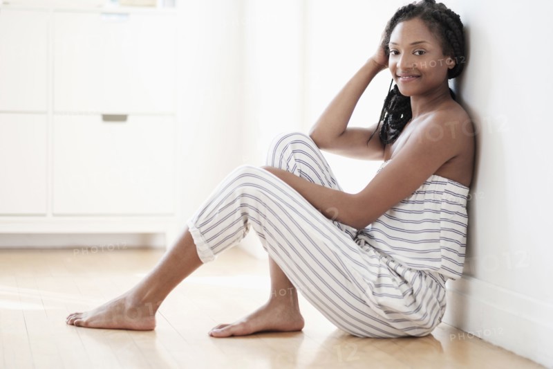 Smiling Black woman sitting on floor