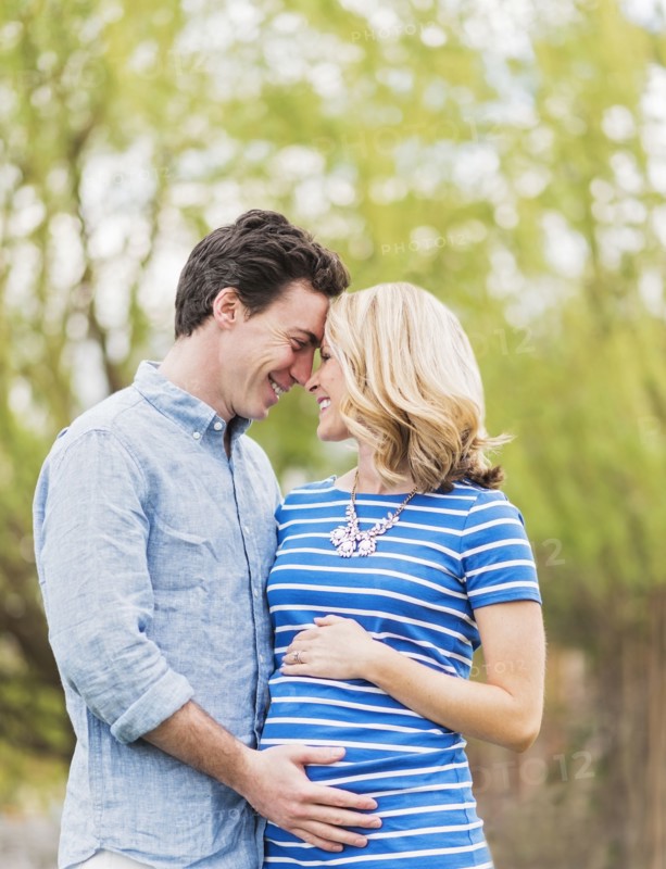 Smiling Caucasian man and expectant mother rubbing noses