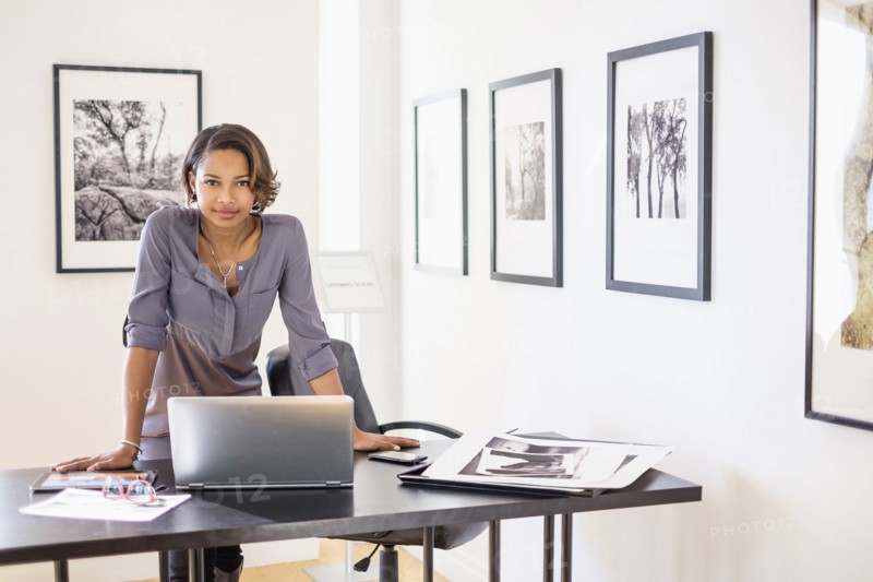 Black woman using laptop in art gallery office