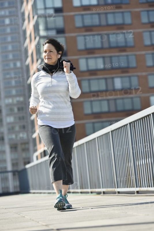 Hispanic woman running in city