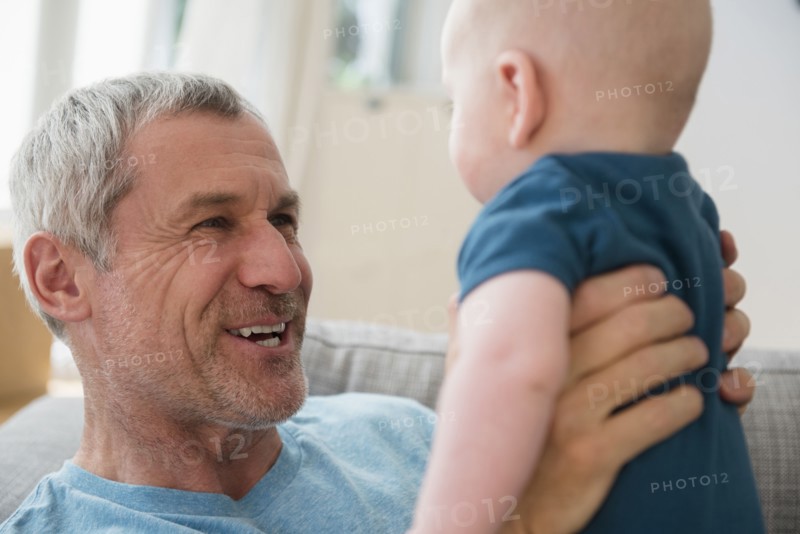 Caucasian grandfather holding grandson face to face