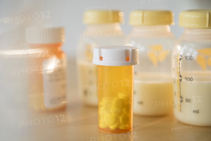 Bottle of prescription pills and bottles of breast milk