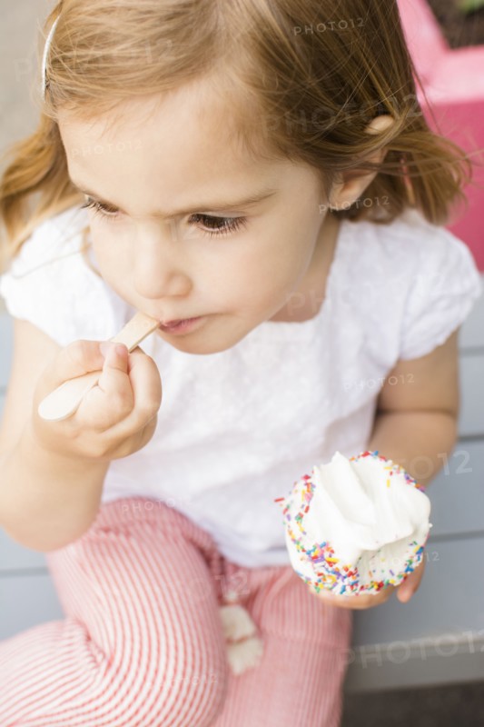 Caucasian girl eating ice cream with spoon