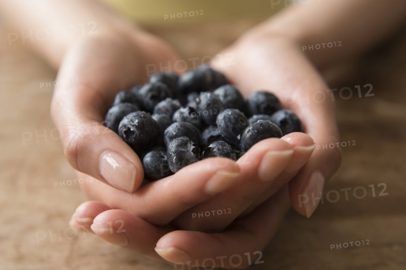 Hands of Hispanic woman holding blueberries