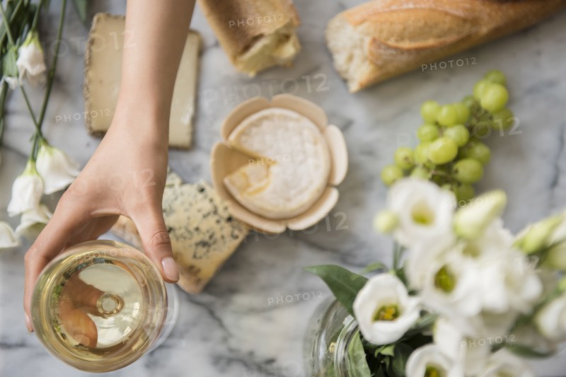 Hispanic woman drinking wine with cheese