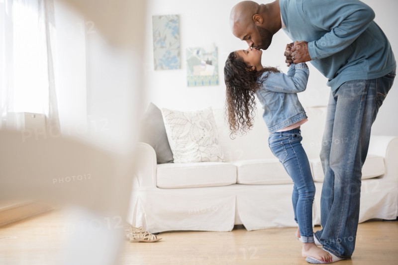 Daughter standing on feet of father and dancing
