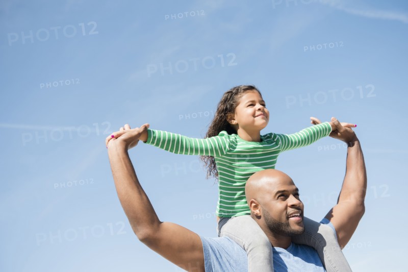 Father carrying daughter on shoulders