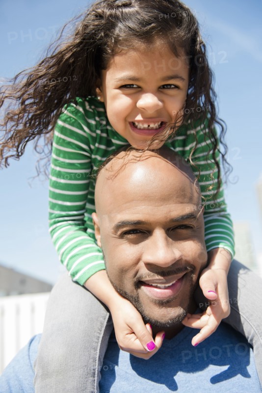 Father carrying daughter on shoulders