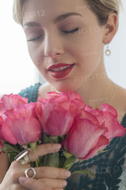Caucasian woman smelling pink roses