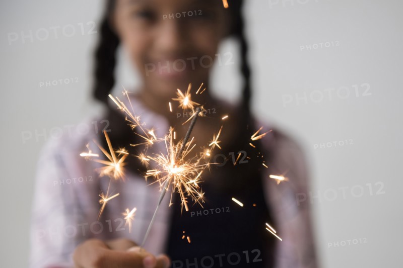 Mixed Race girl holding sparkler