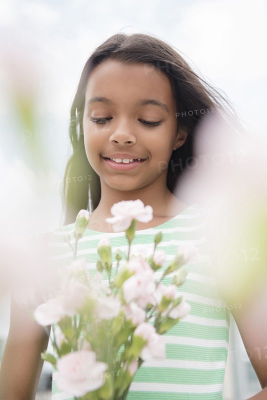 Mixed Race girl holding bouquet of flowers