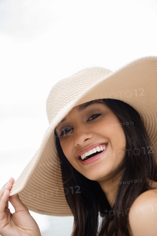 Smiling Mixed Race woman wearing sun hat