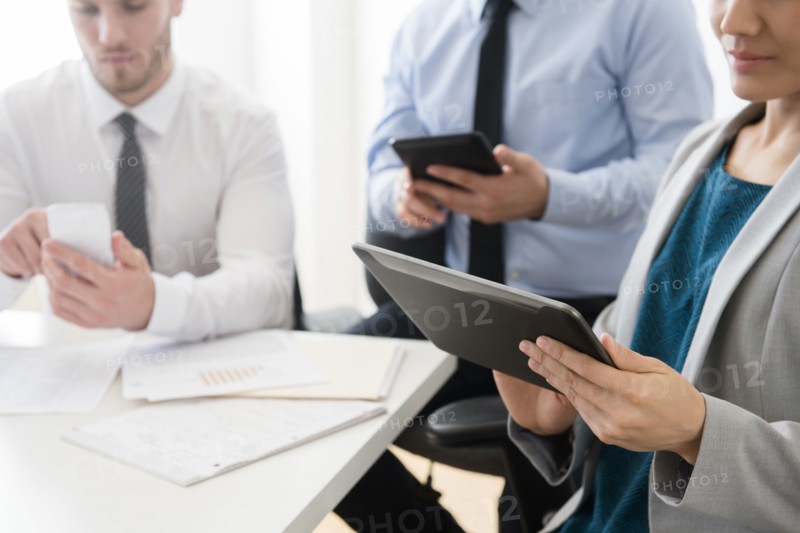 Business people using digital tablets and cell phone in office