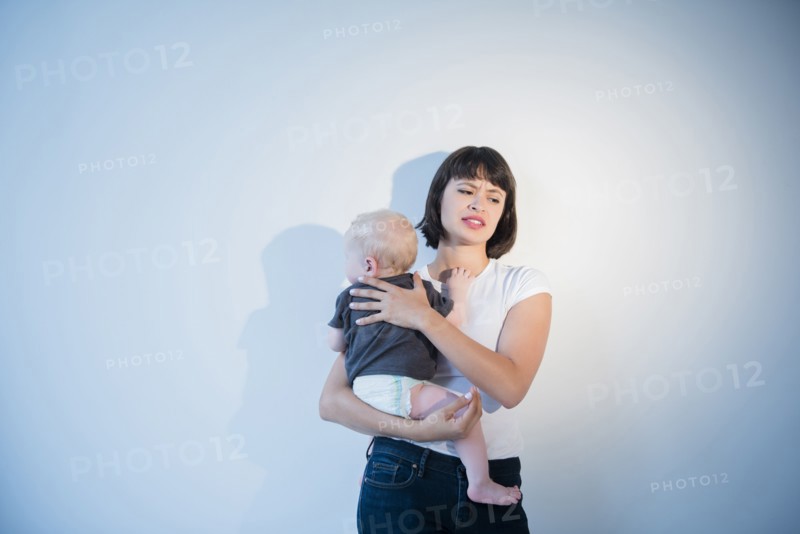 Frustrated mother holding baby son