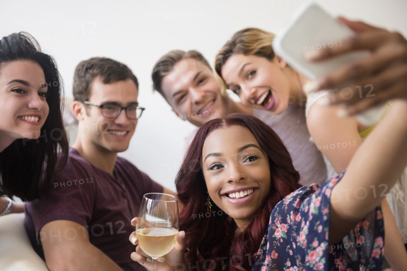 Smiling friends posing for cell phone selfie