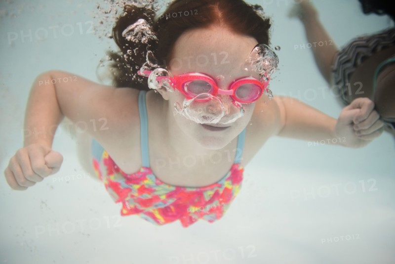 Girl swimming underwater wearing goggles