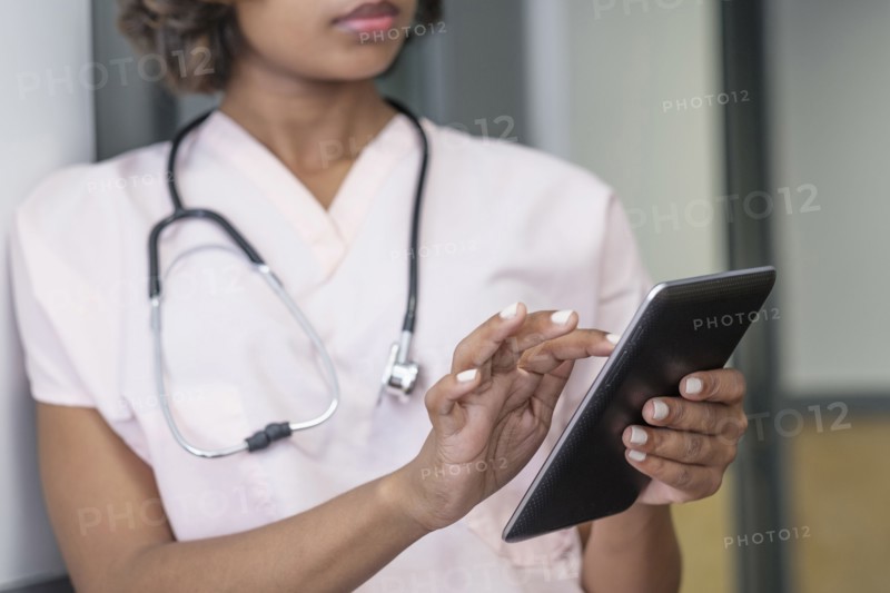 Mixed Race nurse using digital tablet