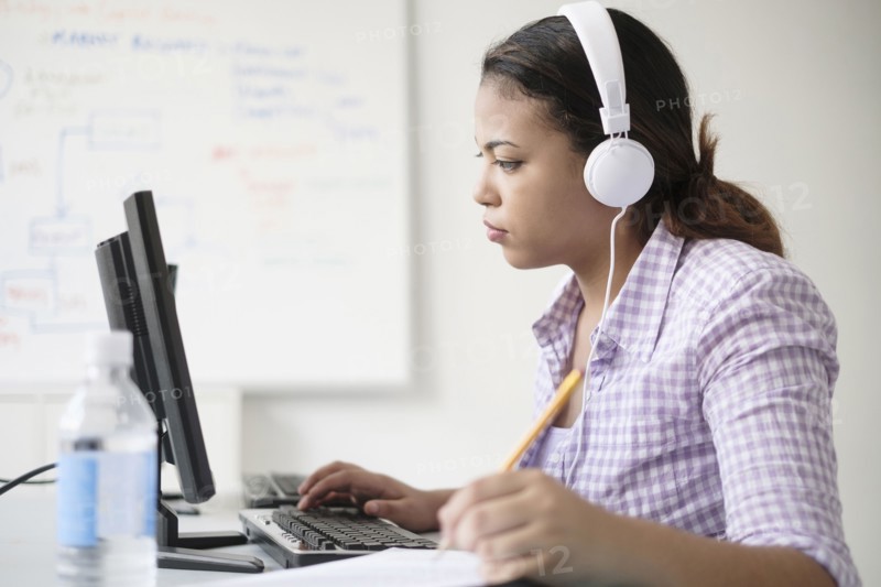 Hispanic woman typing in computer lab