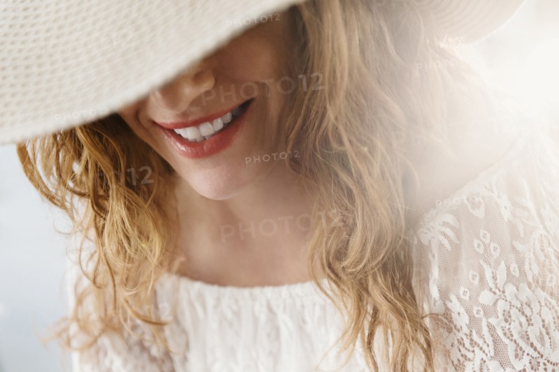 Sun hat covering face of Caucasian woman