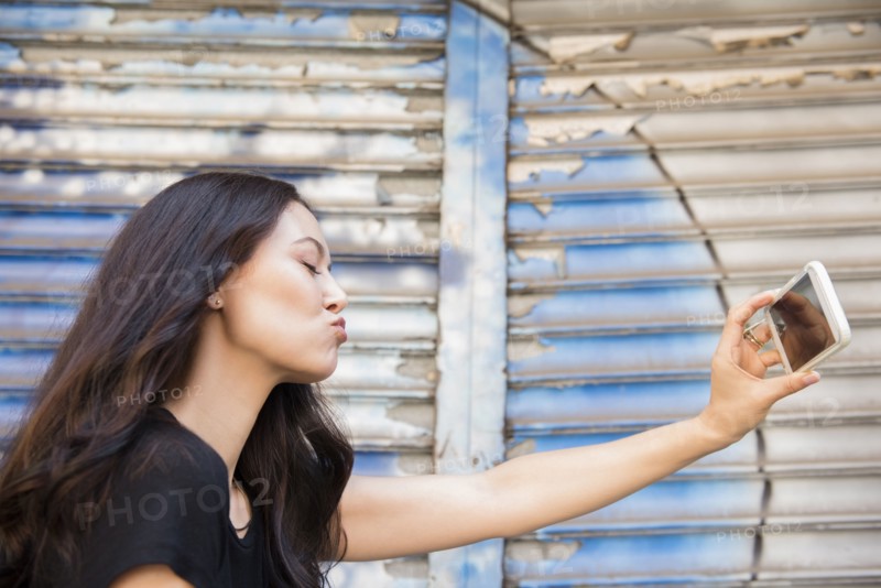 Thai woman puckering for cell phone selfie
