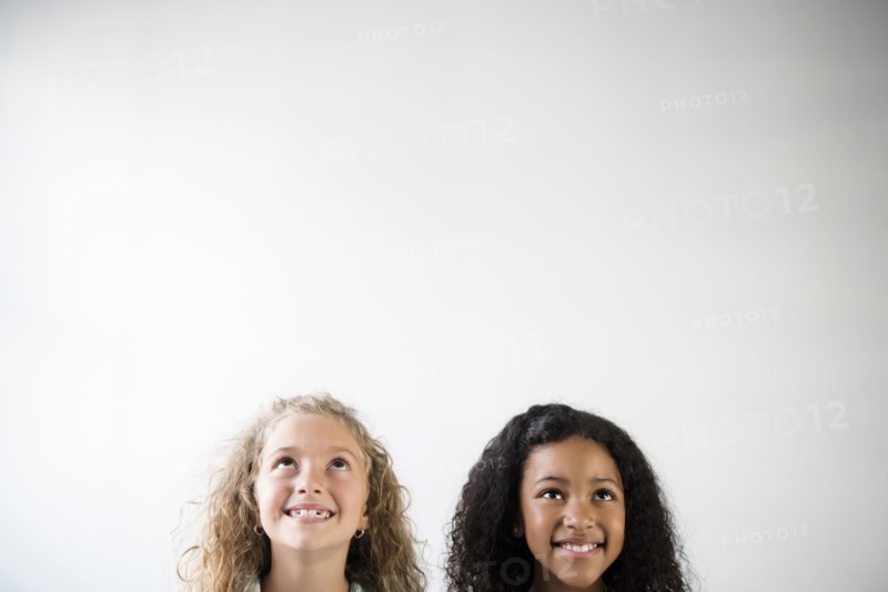 Faces of smiling girls looking up