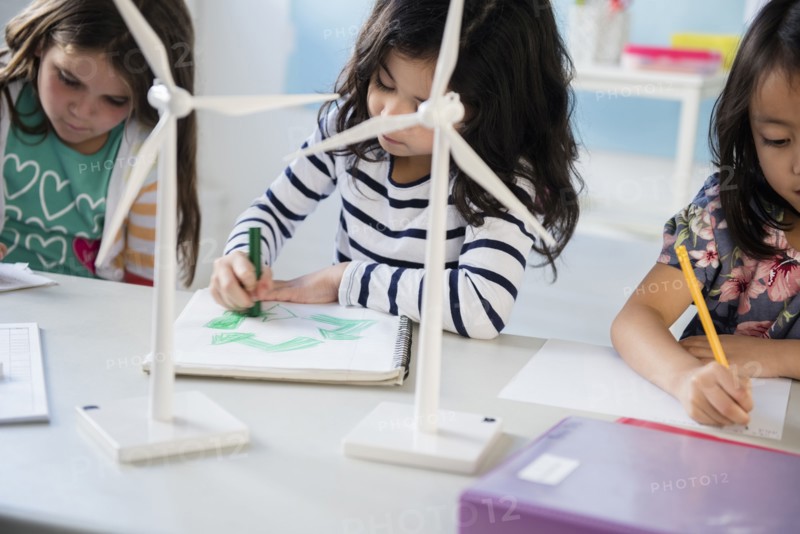 Girls learning about windmills and recycling in classroom