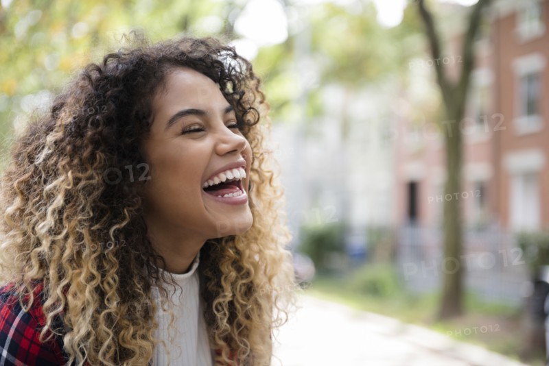 Mixed Race woman laughing in city