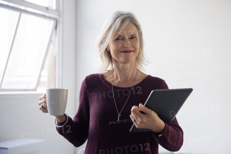 Portrait of Caucasian businesswoman holding coffee cup and digital tablet