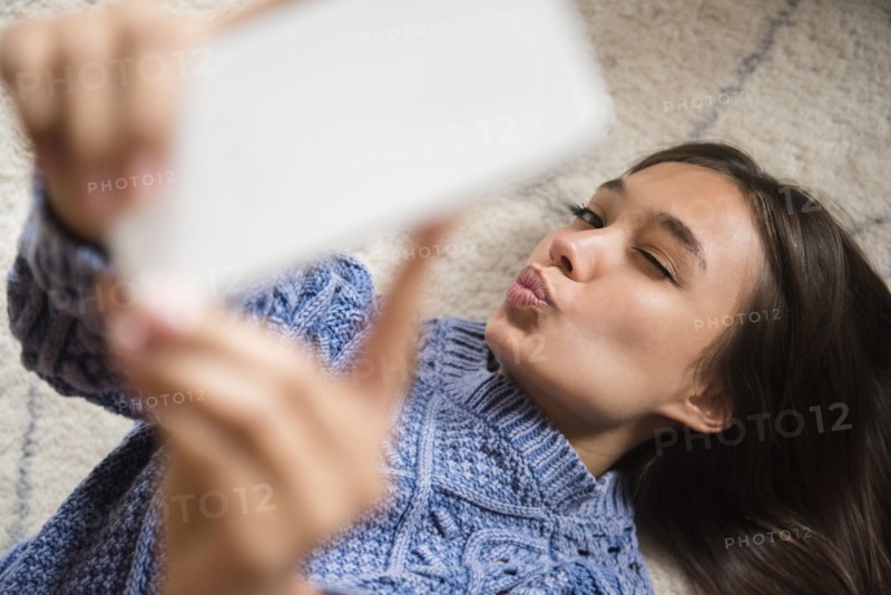Mixed Race woman posing for cell phone selfie