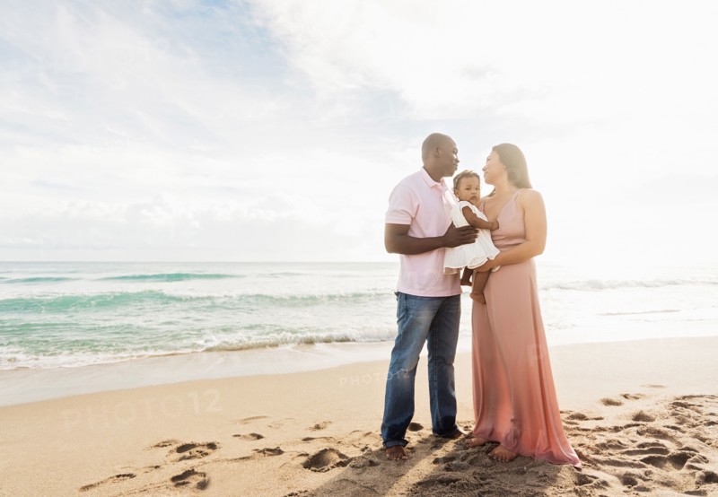 Couple holding baby daughter on beach