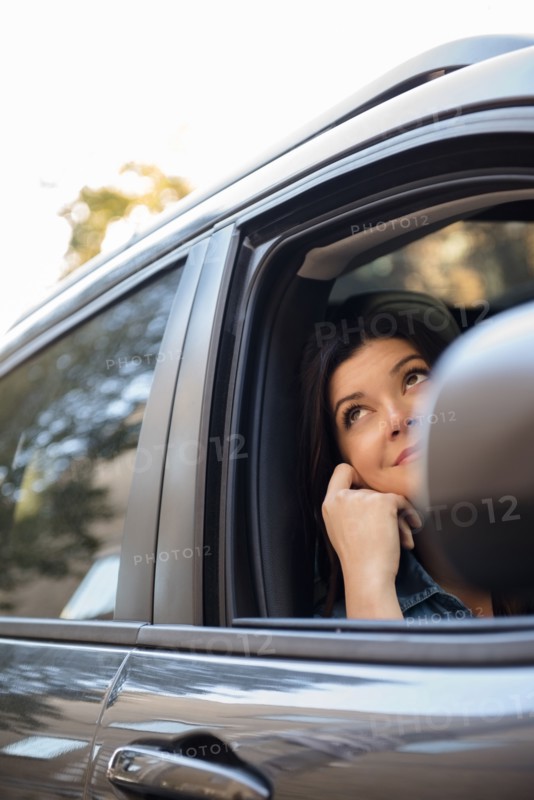 Caucasian woman daydreaming in car