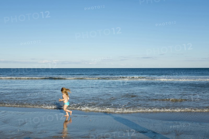 Caucasian girl running on beach