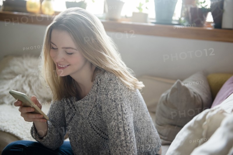 Smiling woman texting on cell phone