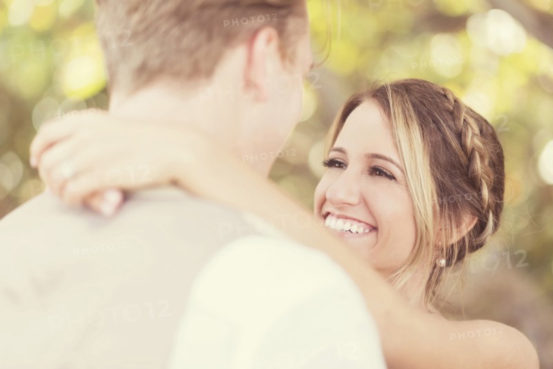 Caucasian bride and groom hugging outdoors