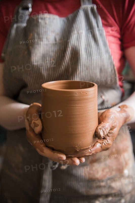 Caucasian woman showing pottery cup