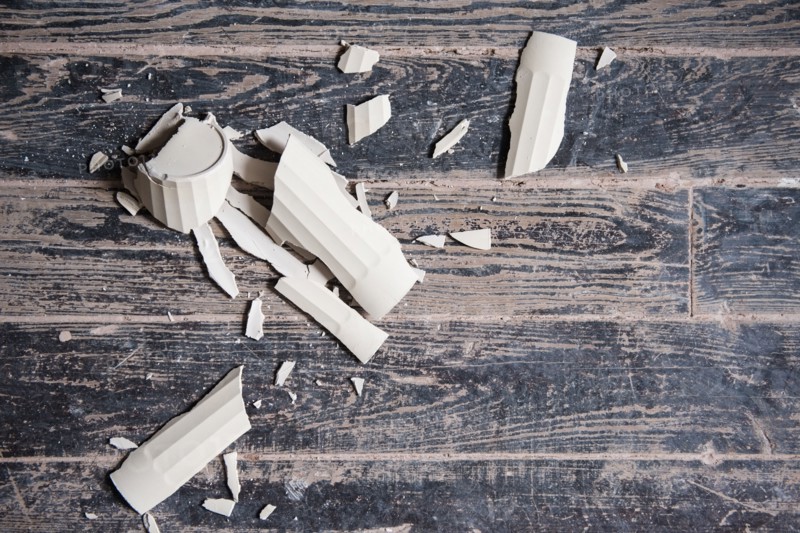 Broken shards of cup on wooden floor