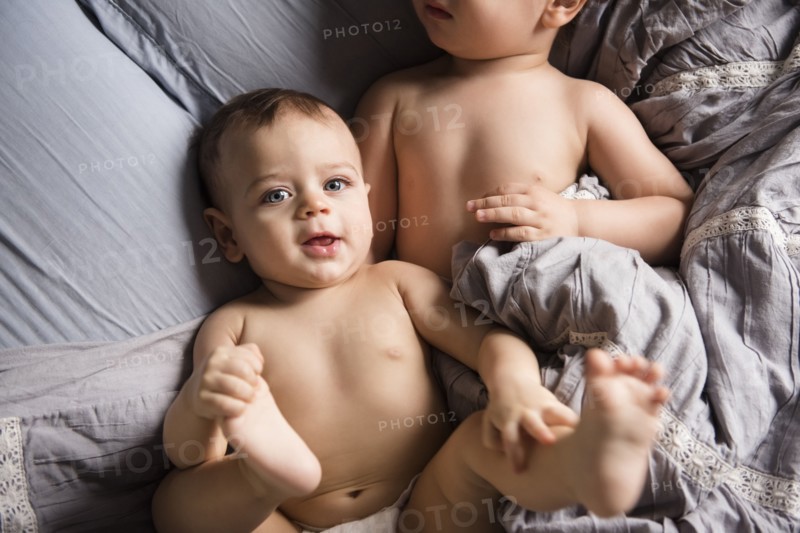 Caucasian boys laying on bed