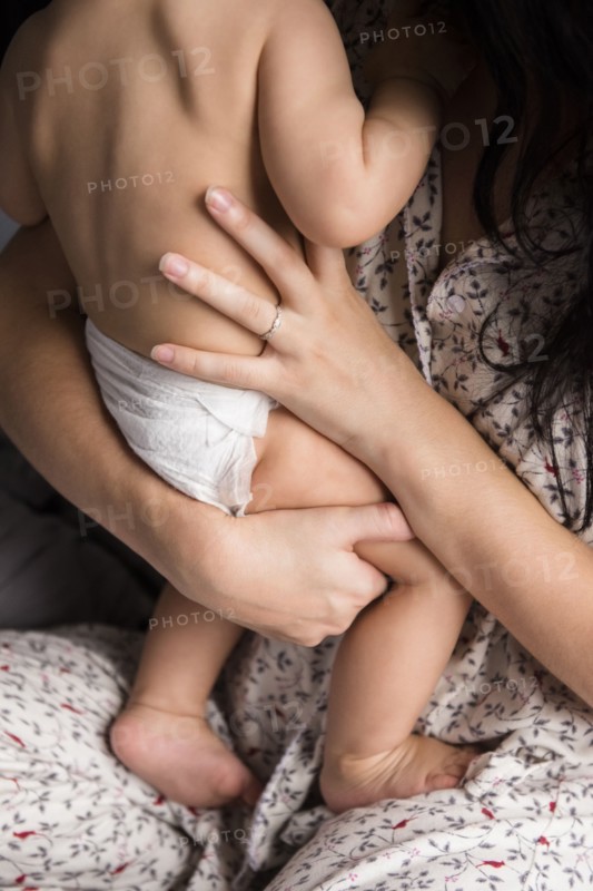 Caucasian mother holding baby son in bed