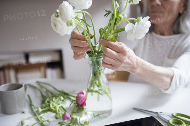 Older woman arranging flowers