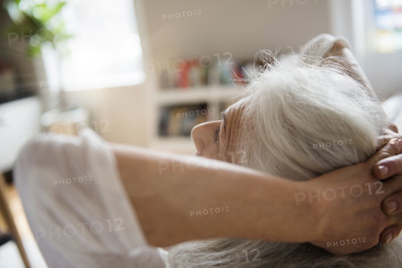 Older woman relaxing with hands behind head