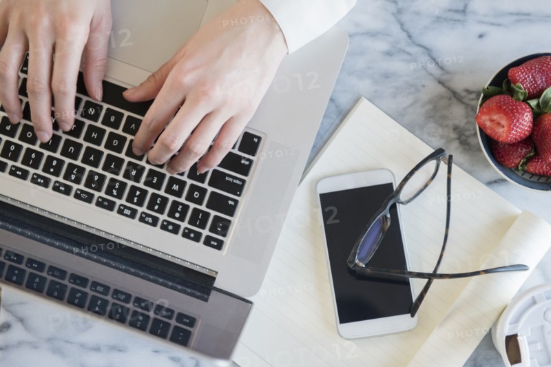 Hands of Caucasian woman typing on laptop