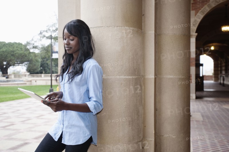African American student using digital tablet outdoors