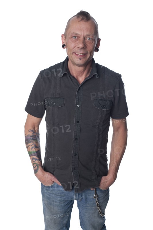 Tattooed Caucasian man with hands in pockets