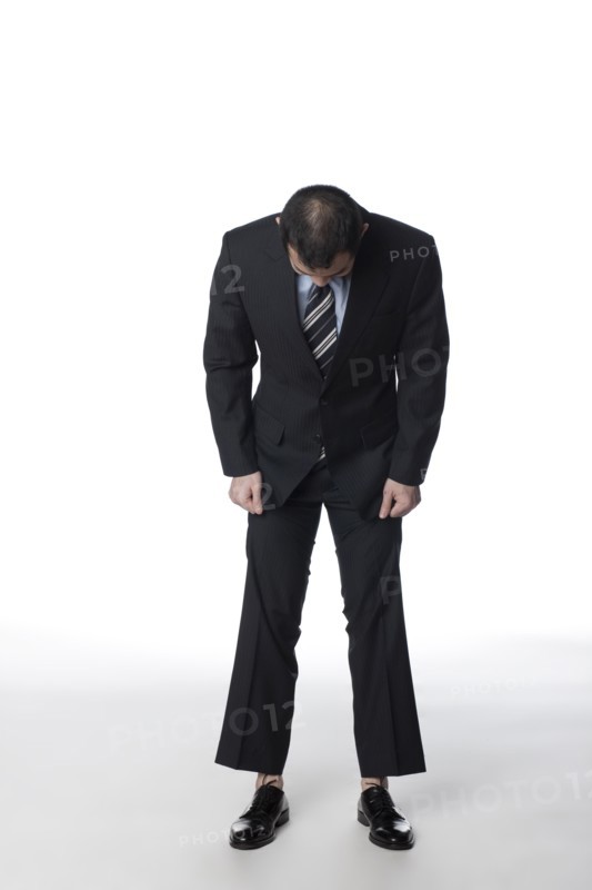 Chinese businessman looking at his shoes