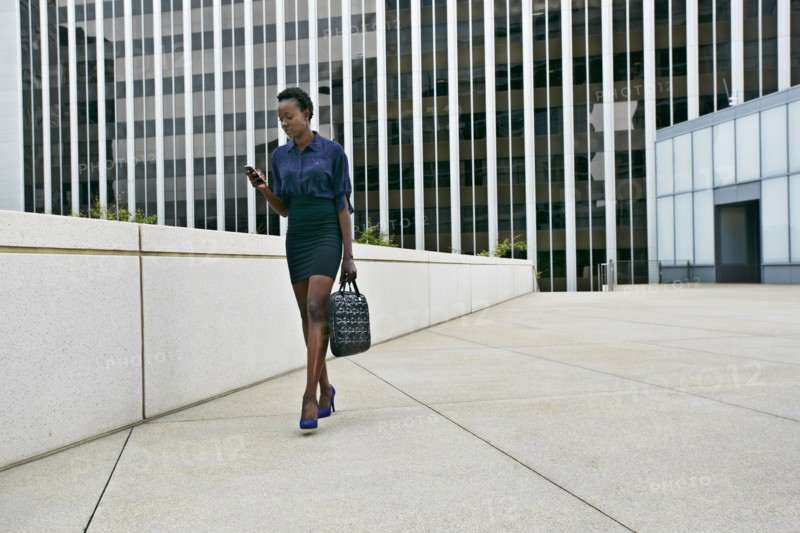 African American businesswoman walking on city street