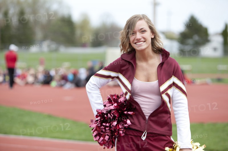 Caucasian cheerleader smiling on track