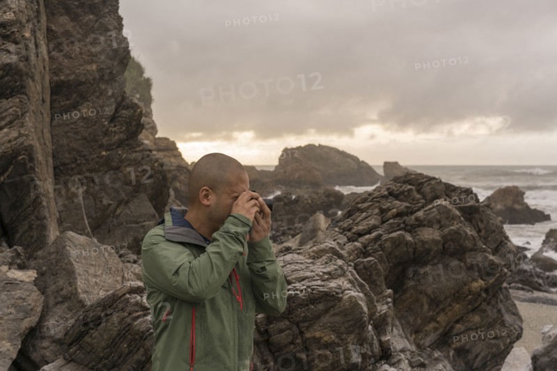 Chinese man photographing ocean
