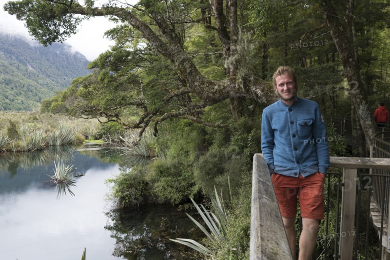 Caucasian man smiling near railing at river